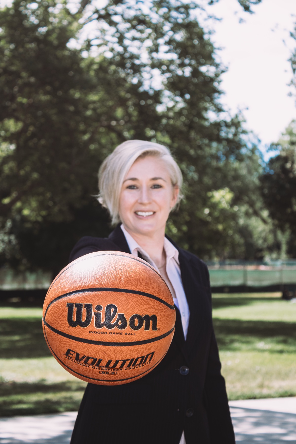 Coach Julz posing with a basketball